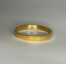 Load image into Gallery viewer, Gouden brede Stainless steel armband met tekst “La vie est belle”
