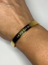 Load image into Gallery viewer, Gouden brede Stainless steel armband met tekst “La vie est belle”
